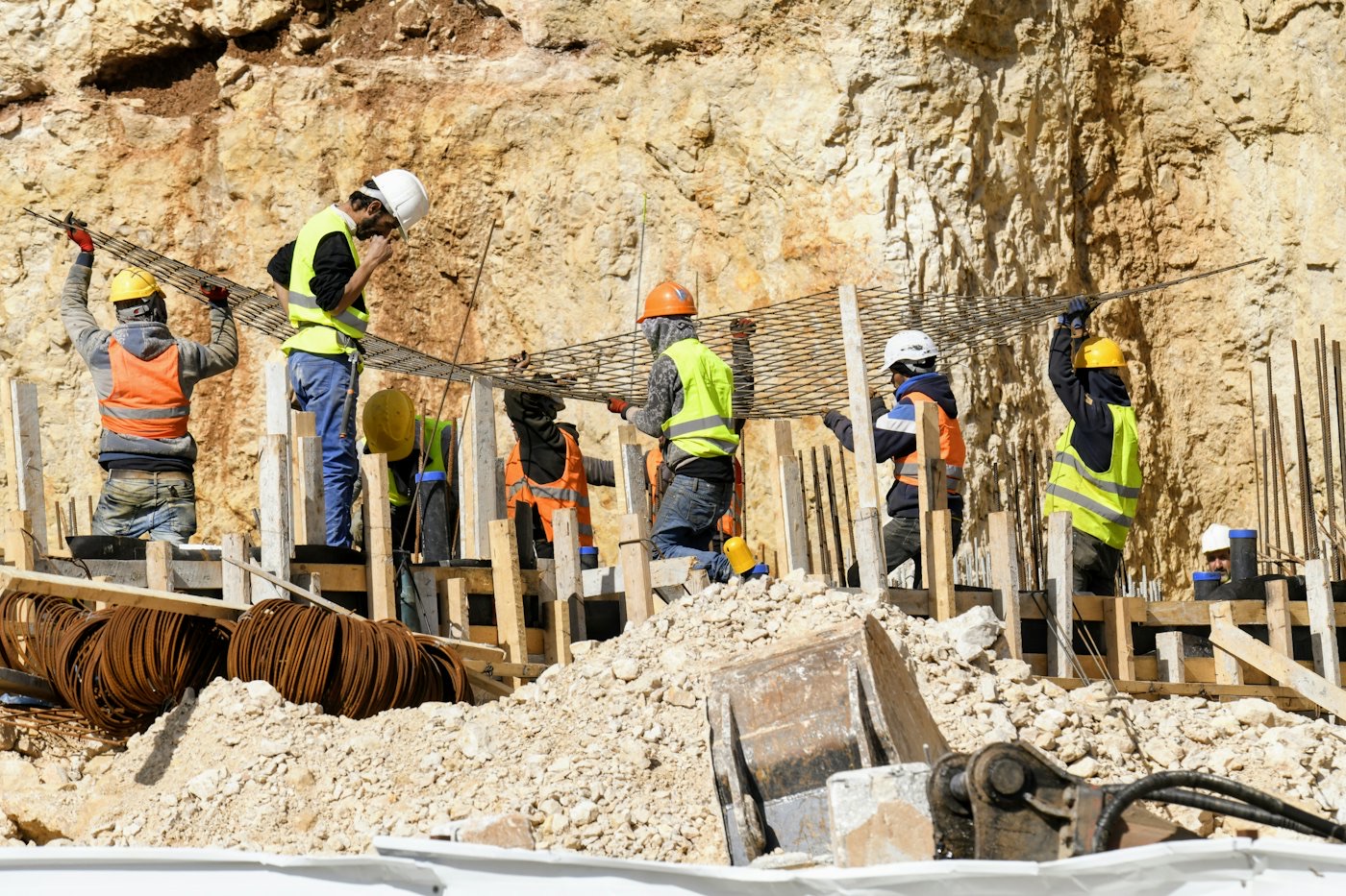 Site team working at a rock cut with formwork and rebar