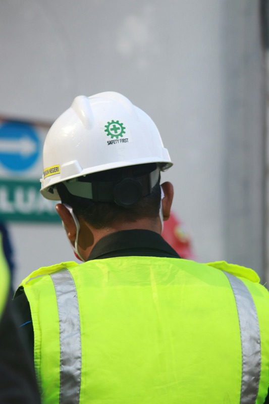 White helmet with a green safety logo and yellow hi-vis vest