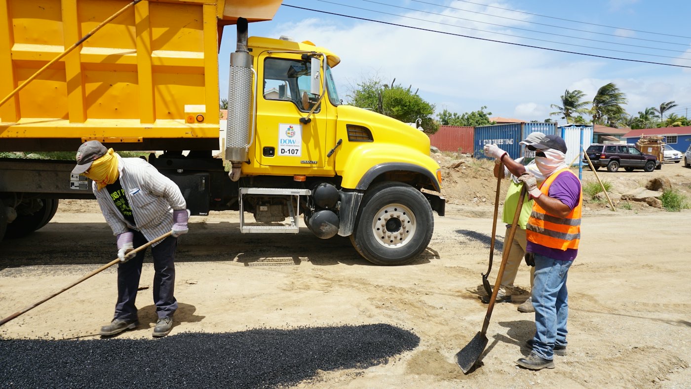 Yellow GON delivery truck with two workers on site