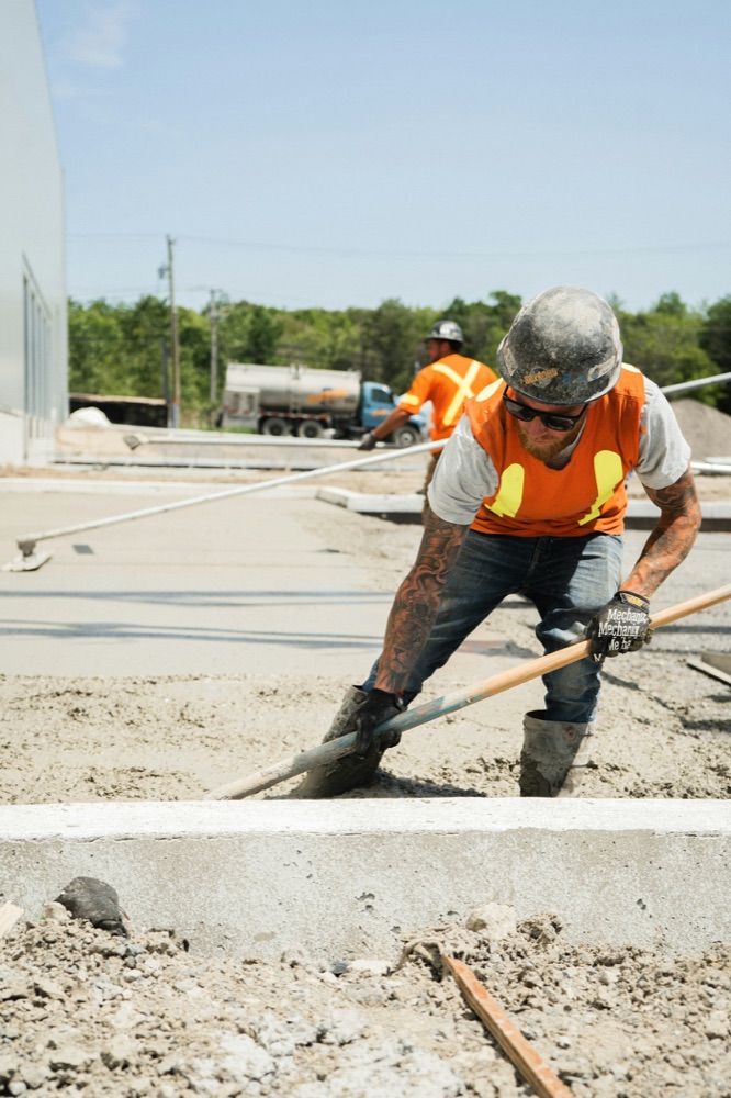Worker with a shovel on a road site